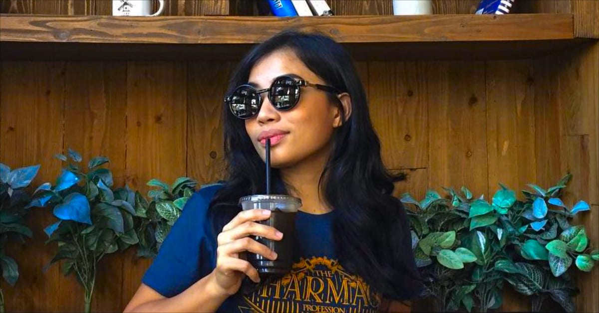An older Filipina with sunglasses drinking soda